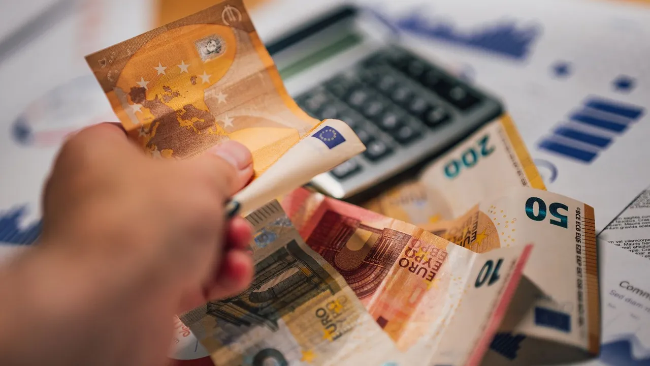 Anciens billets en lires italiennes posés près d'une calculatrice et d'une pièce d'un euro.